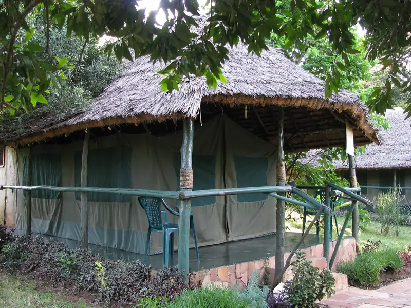 Safari tent with a thatched roof at a Kenyan tented camp
